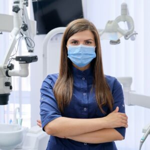 Portrait of young female doctor dentist in medical face mask in dental office